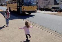 Girl runs to hug brother as he gets off school bus