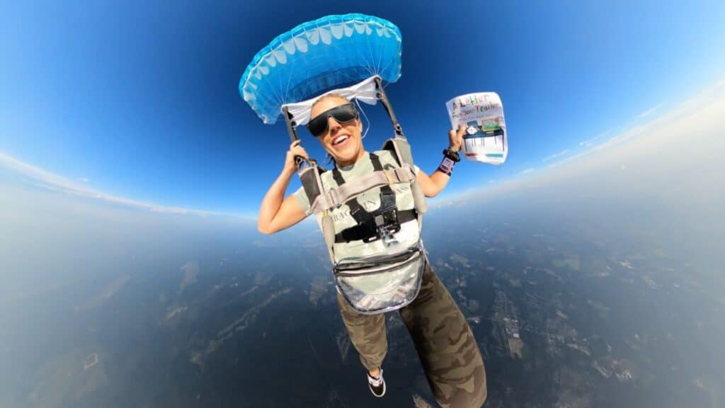 Rebecca reads the book as she descends from 13,000ft during the skydive