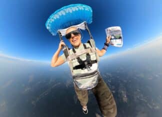 Rebecca reads the book as she descends from 13,000ft during the skydive