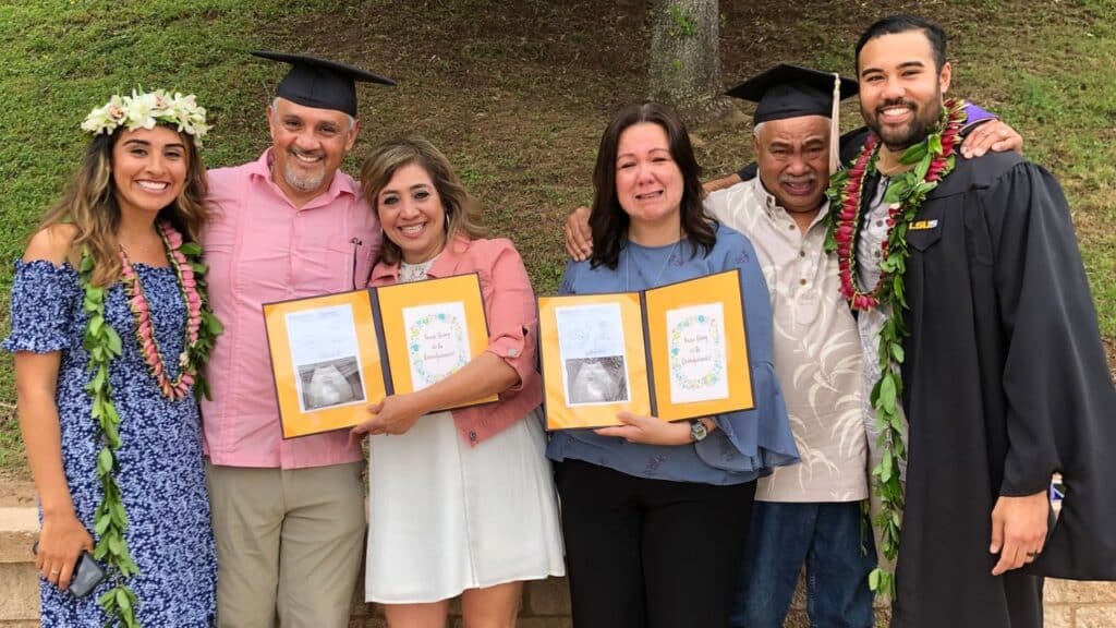 The parents with tears in their eyes pose with the graduation booklets that announced the news.