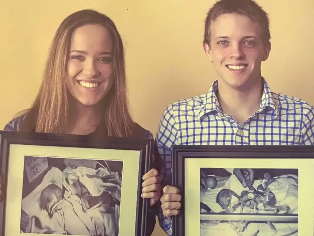 Rachel and Hayden holding images of themselves as babies in the NICU at Corewell Health Dearborn Hospital