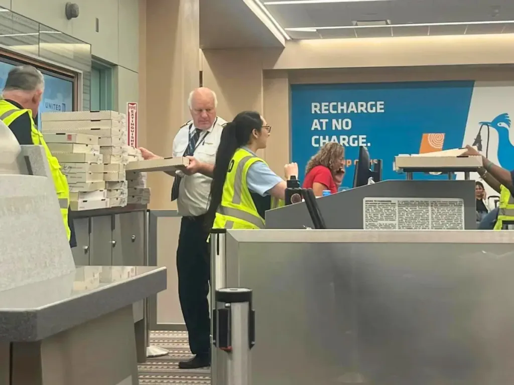 United pilot Scott Wardle dishes out pizza to stranded passengers.