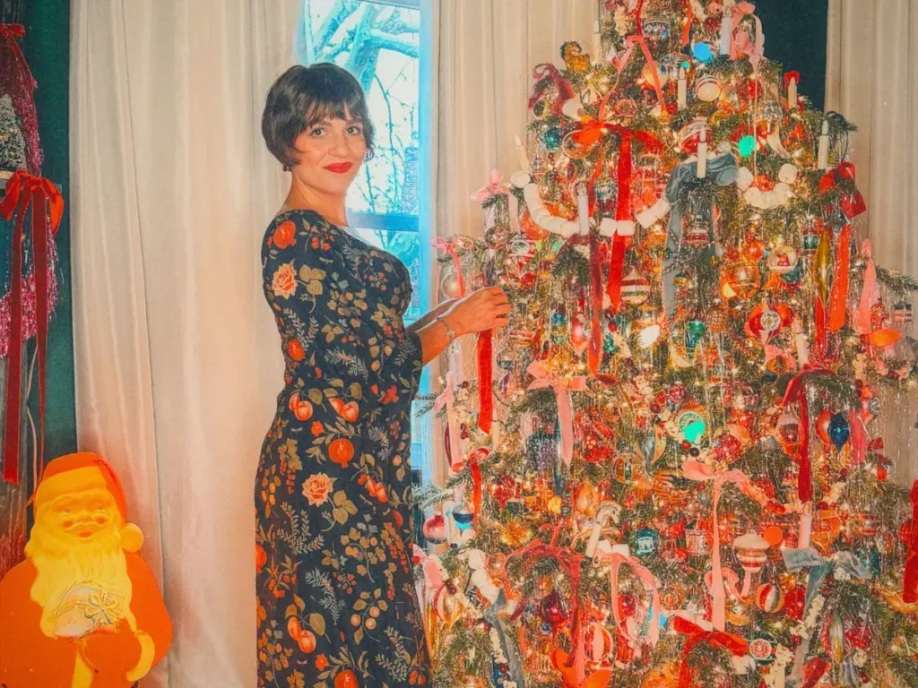 Erika Kikola next to her maximalist Christmas tree.