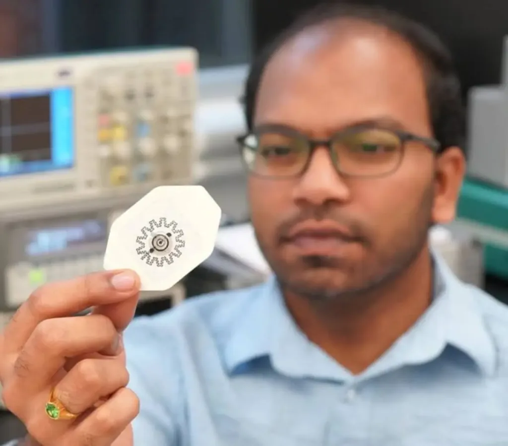 Photo of researcher Rajaram Kaveti holding the water-powered, electronics-free dressing (WPED) for electrical stimulation of wounds. 