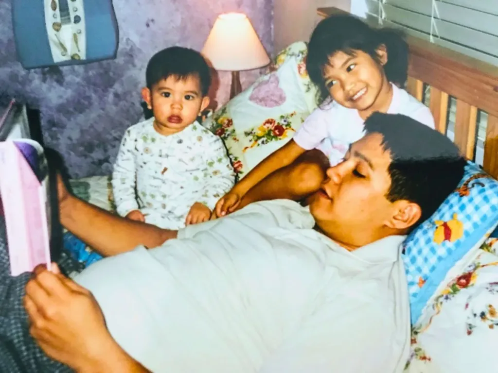 Sierra's dad reading her and her sibling Winnie the Pooh.