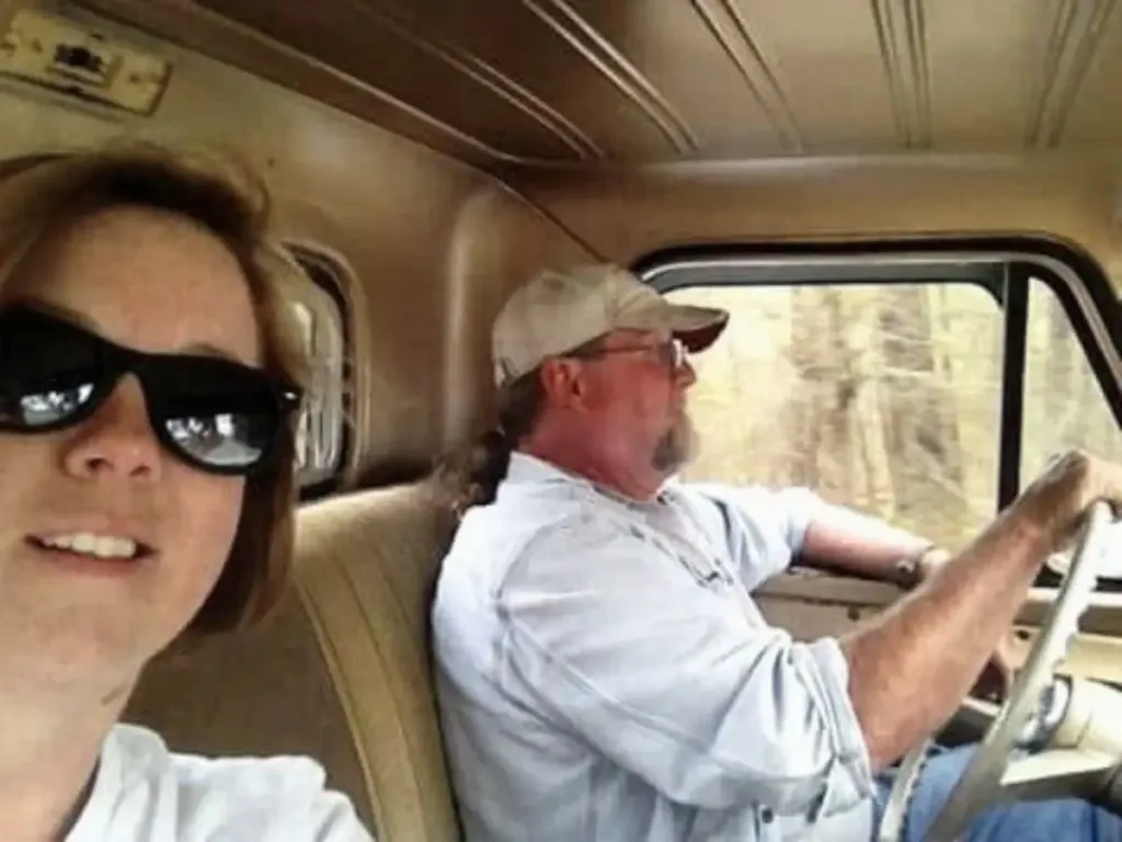 Donnie Couch driving the Chevy truck, seated next to his daughter Tina, who is taking a selfie.