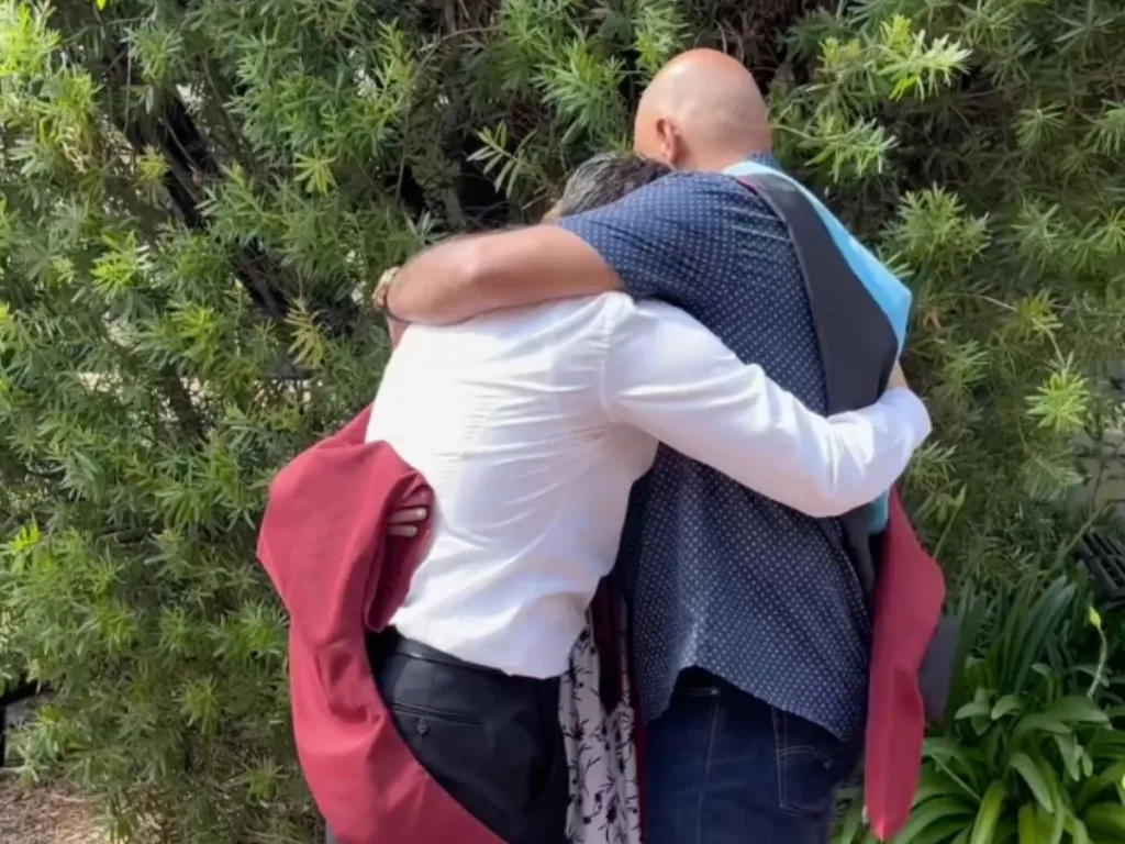 Martin Jr. embraces both parents after dressing them in his graduation gown and hood during an emotional surprise.