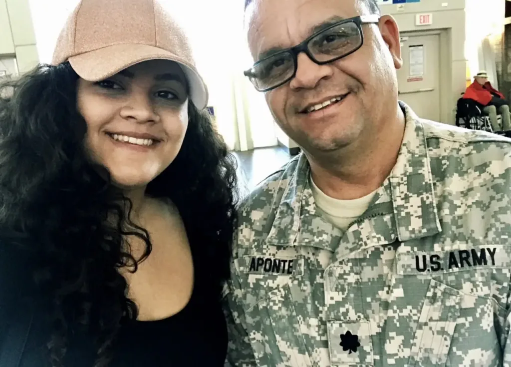 Ariana and her father Alvin Aponte Gonzalez smiling together in military uniform at a retirement event.