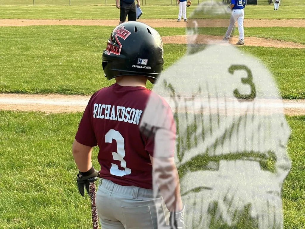 Boy in a number 3 jersey stands with a bat, with a faded image of Babe Ruth wearing the same number superimposed.