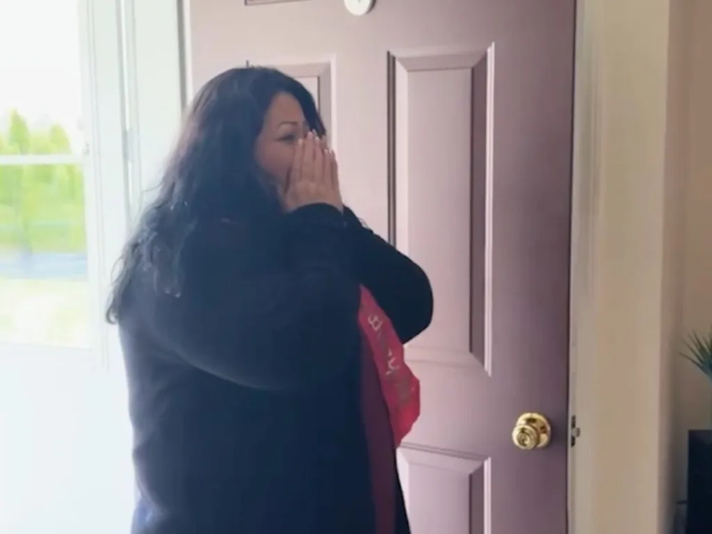 Alma Soqui holds her hands to her face in shock as she walks into her surprise birthday party.