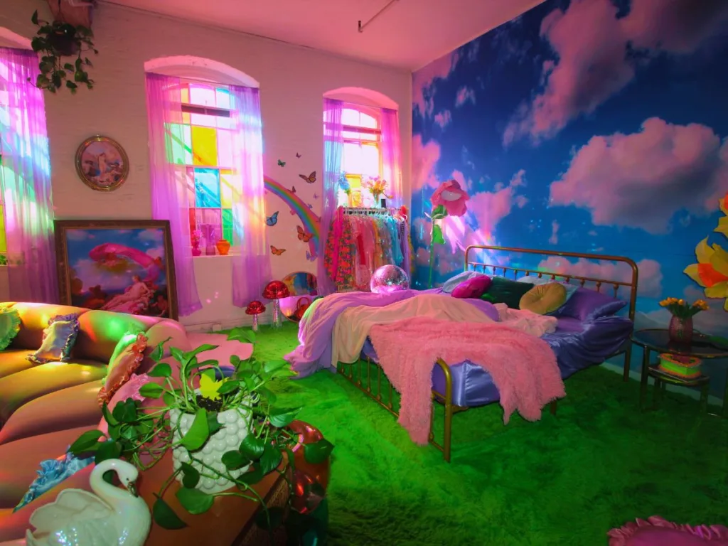 Dreamcore-style bedroom with cloud wall mural, green carpet, pink and purple bedding, and butterfly wall decals.