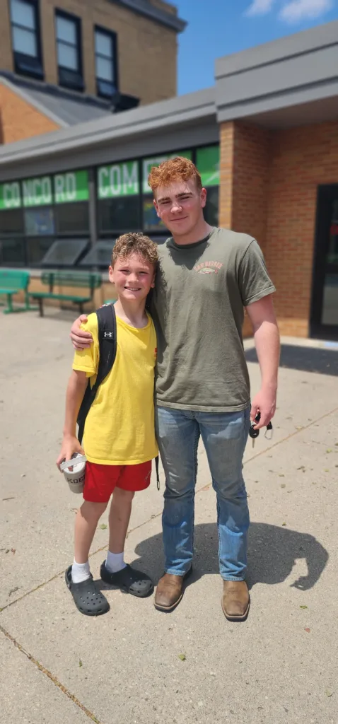 Marine Brandon Orsi poses outside a school with his younger brother Koen after surprising him.