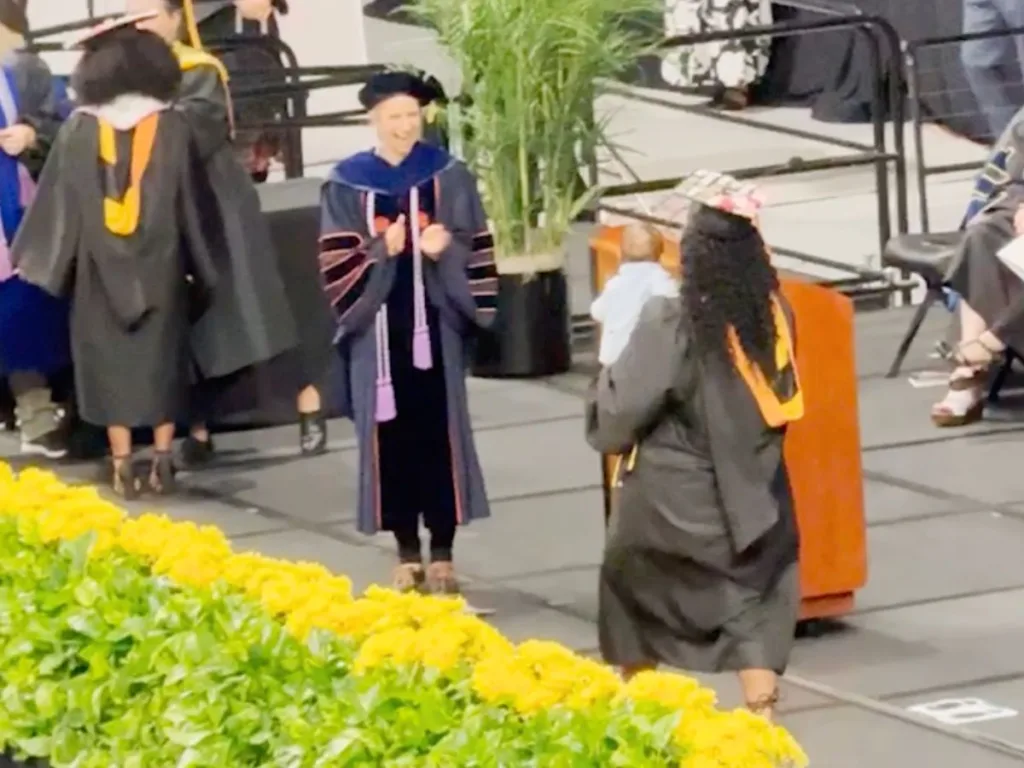 Nursing graduate Jada Hargrove proudly carries her baby across the graduation stage.