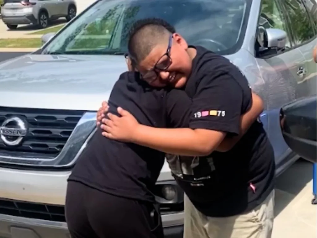 Two boys hug tightly in emotional reunion after being separated for a year.