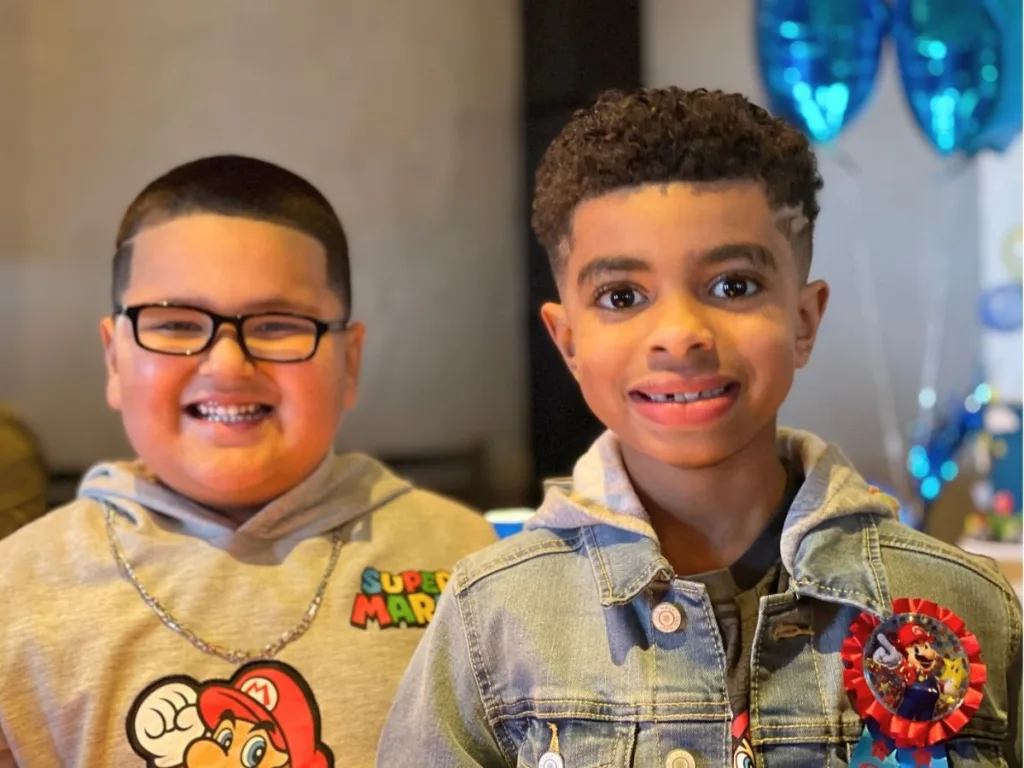 Two smiling boys pose together, celebrating their close friendship.