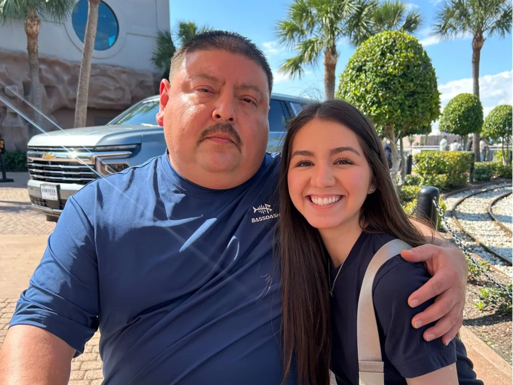 Steven Lopez with arm around stepdaughter Daisy Garcia posing for photo outdoors in Houston after adoption surprise.