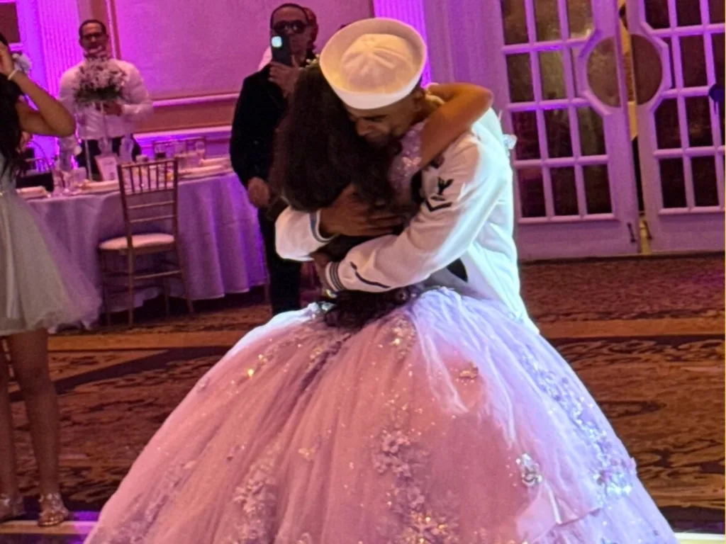 Chris, in a Navy uniform, hugs Alexa as she wears a purple quinceañera gown.