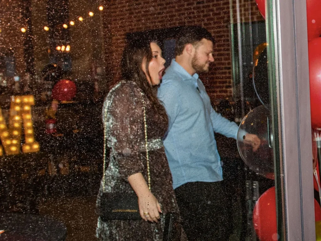 Kim reacts in surprise as Hunter leads her inside on a rainy night.