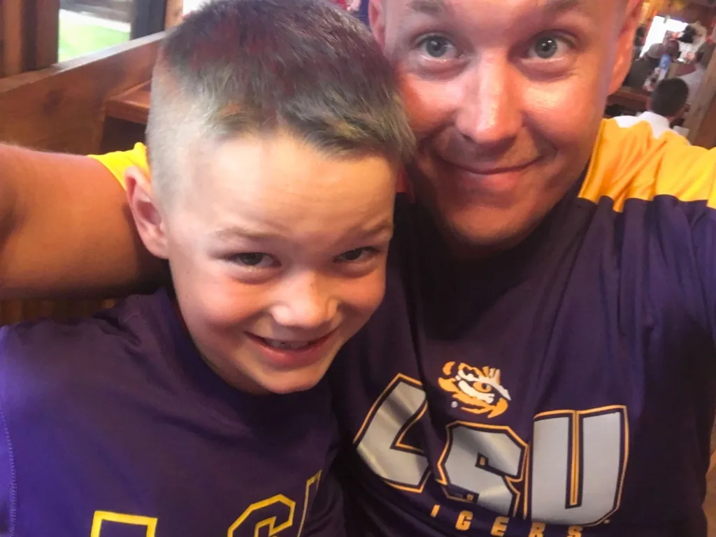 Jason smiles beside Levi in an older photo showing the pair together in LSU shirts.