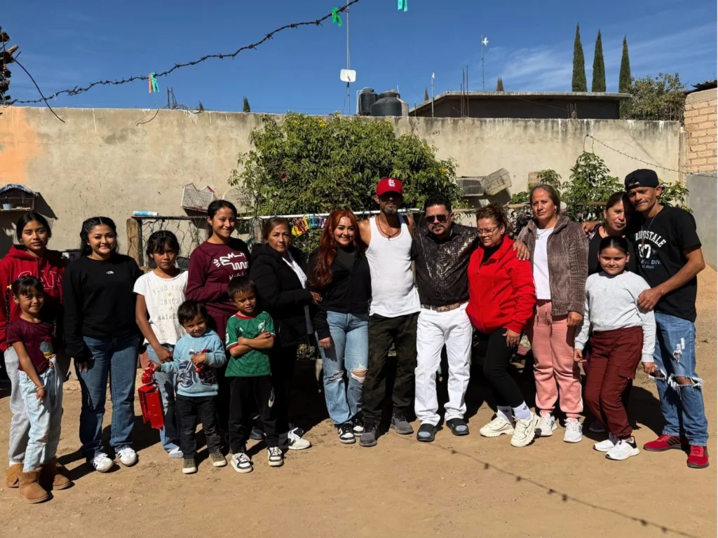 Hugo stands surrounded by relatives of different generations during a family reunion in Mexico.