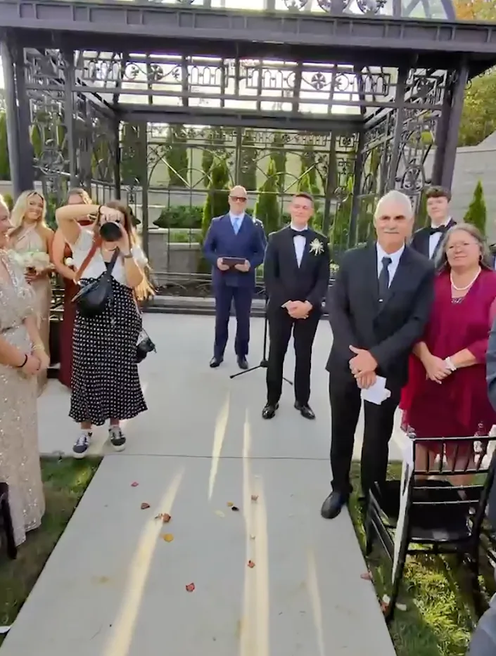 A POV shot from Greg's Meta Glasses as he walks Madison down the aisle.