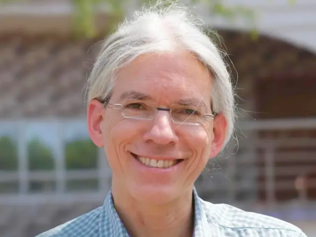 Martin Aufmuth, German math teacher and founder of the One Dollar Glasses non-profit, smiles to camera.
