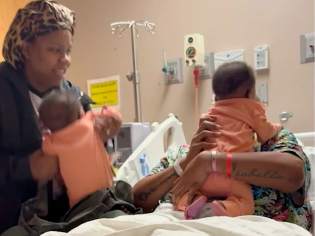 Brittany reacts in a hospital room as Monique surprises her with baby twins Teagan and Tatum