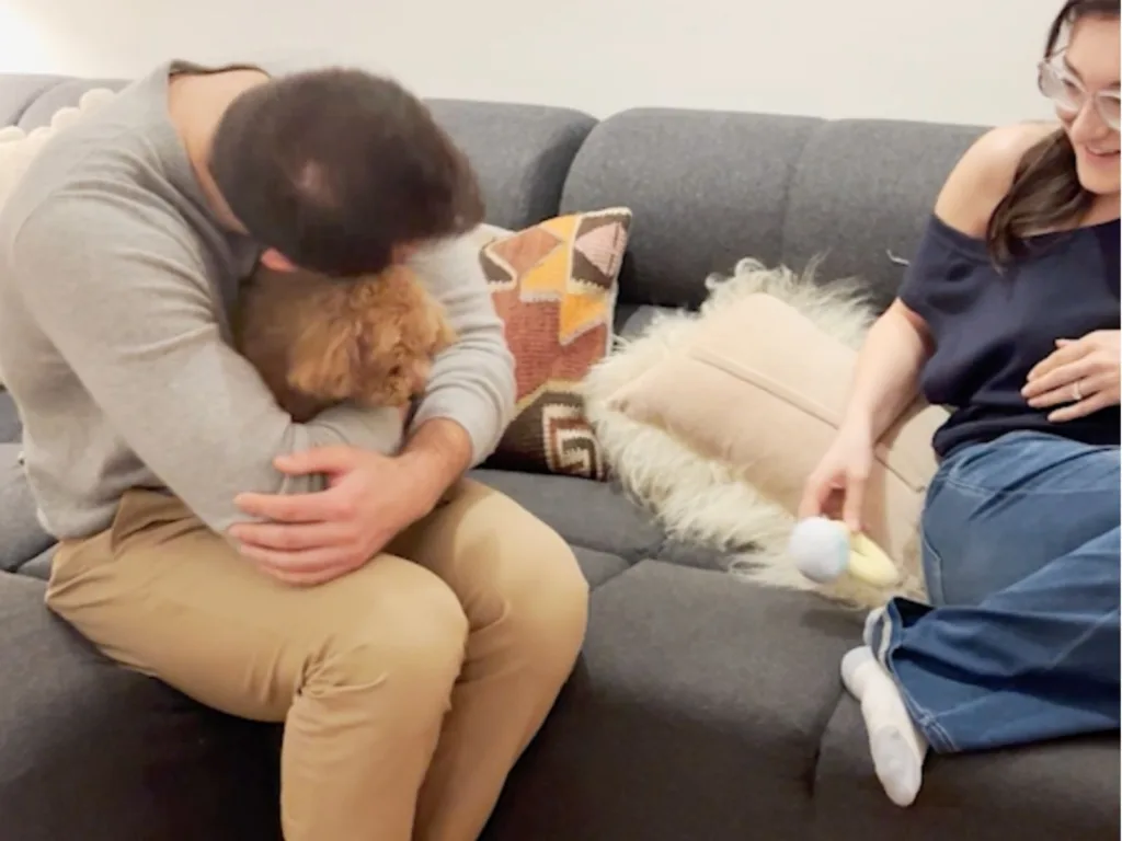 Matthew hugs Rosie on the couch as Ila smiles beside them.