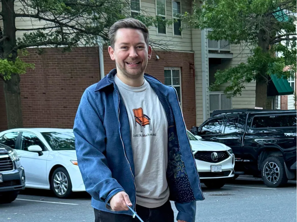 Eric smiles while wearing the finished blue jacket, with the patterned lining visible inside.