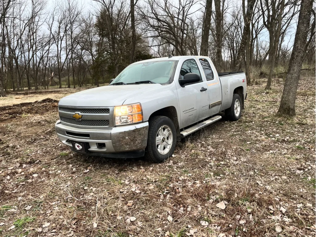 Justin’s silver Chevrolet Silverado parked in a wooded area before it was given to Gage.