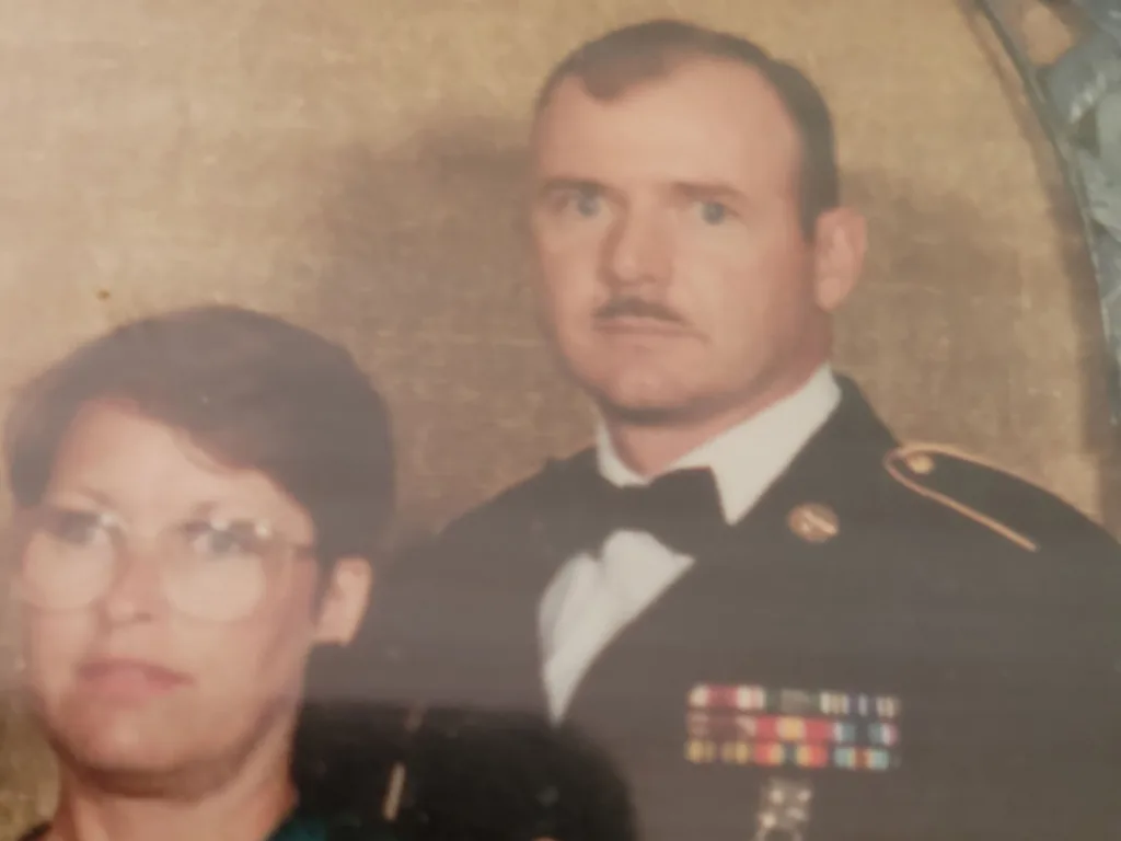 An old military portrait shows Roger in uniform posing beside a woman.